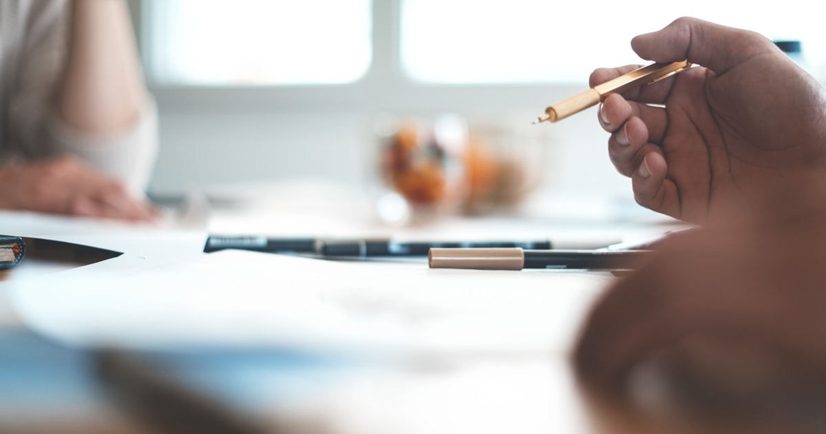 shallow focus photo of person wearing ballpoint pen