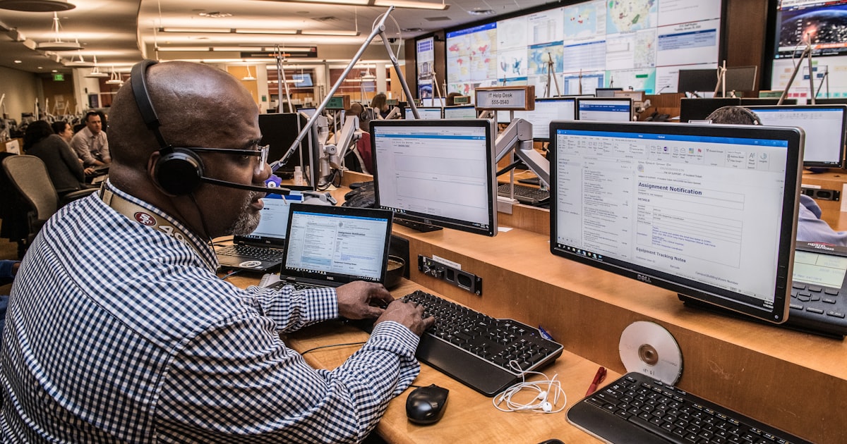 man in black and white checkered dress shirt using computer