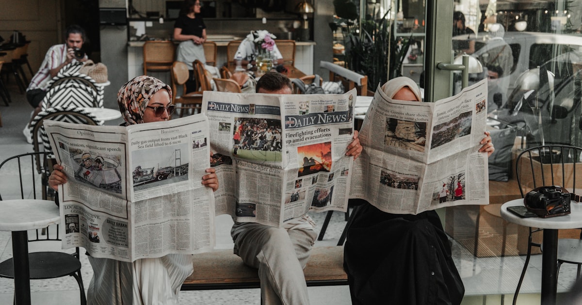 A man sitting on a bench reading a newspaper