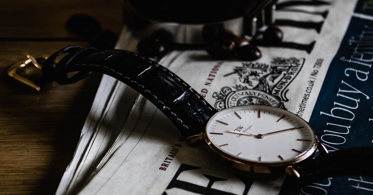 a watch sitting on top of a newspaper