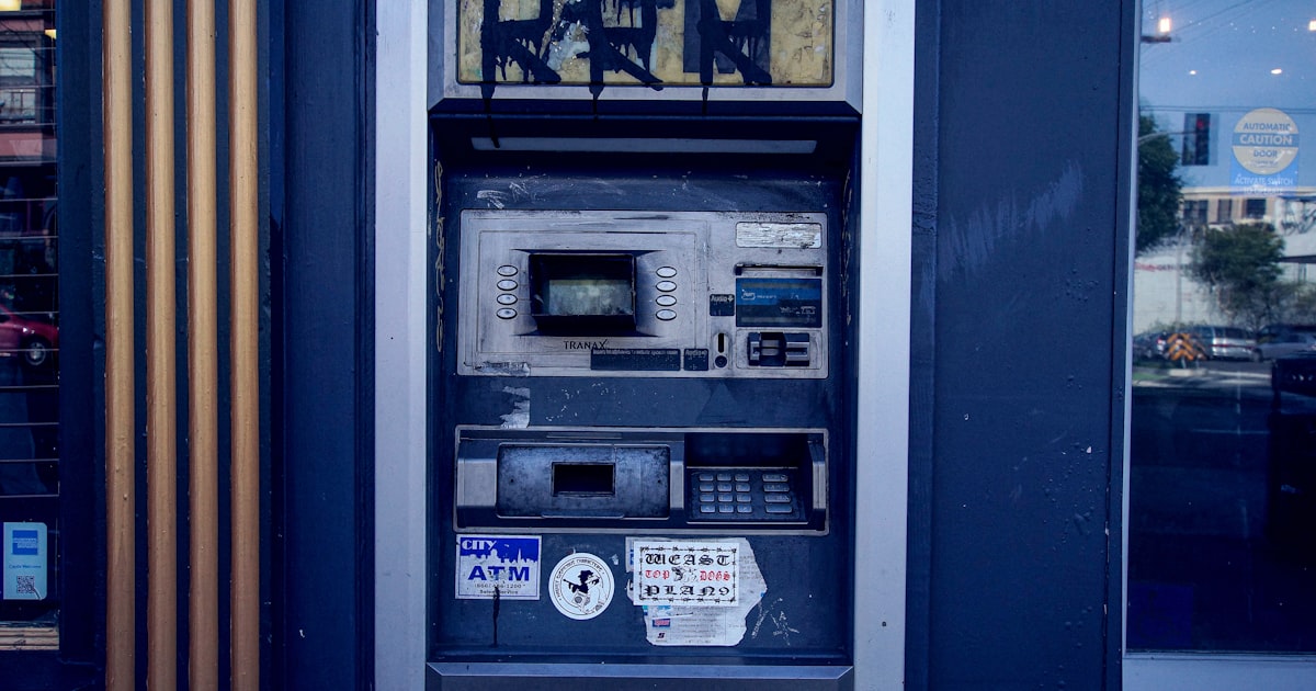 an old fashioned payphone with graffiti on the side of it